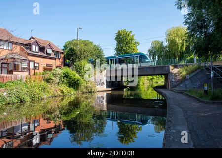 Tram che attraversa Nottingham e Beeston Canal in una giornata estiva soleggiata a Lenton, Nottinghamshire Inghilterra Regno Unito Foto Stock