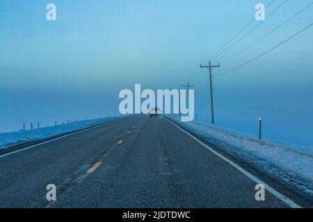 USA, Idaho, Fairfield, auto in direzione di Fogbank lungo l'autostrada 20 in inverno Foto Stock