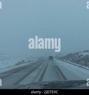 USA, Idaho, Fairfield, strada rurale coperta dalla neve vista dall'auto Foto Stock