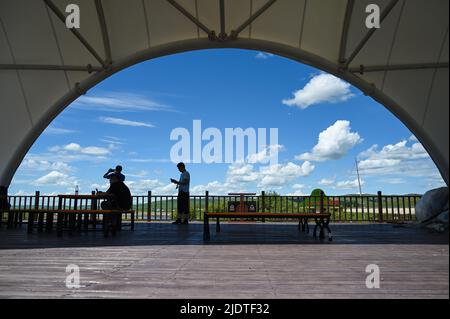 (220623) -- LEGA di HINGGGAN, 23 giugno 2022 (Xinhua) -- i turisti si riposano in un punto panoramico della prateria di Ulan Mod in Horqin Banner anteriore dell'ala destra della Lega di Hinggan, regione autonoma della Mongolia interna della Cina del nord, 23 giugno 2022. (Xinhua/Liu lei) Foto Stock