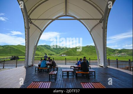 (220623) -- LEGA di HINGGGAN, 23 giugno 2022 (Xinhua) -- i turisti si riposano in un punto panoramico della prateria di Ulan Mod in Horqin Banner anteriore dell'ala destra della Lega di Hinggan, regione autonoma della Mongolia interna della Cina del nord, 23 giugno 2022. (Xinhua/Liu lei) Foto Stock