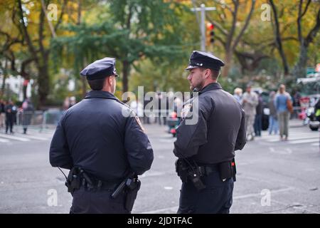 Manhattan, USA - 11. Novembre 2021: NYPD funzionari di polizia in piedi sul lato della strada che fornisce la sicurezza per Veterans Day Parade Foto Stock
