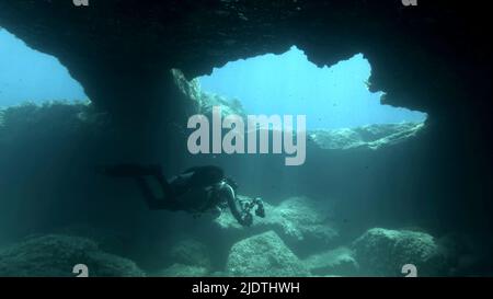 Il fotografo subacqueo nuota nella grotta. Cave diving nel Mar Mediterraneo, Cipro Foto Stock