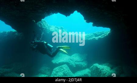 Il fotografo subacqueo nuota nella grotta. Cave diving nel Mar Mediterraneo, Cipro Foto Stock