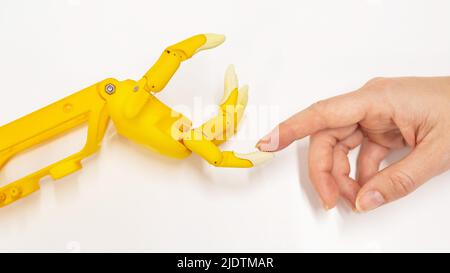 Mano della donna e protesi di plastica per un bambino su sfondo bianco. Foto Stock