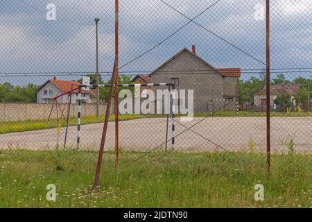 Superficie di cemento campo di calcio terreno in Village Foto Stock