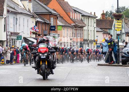 UCI Women's Tour International cycle race peloton passando attraverso la High Street della città di mercato di Hadleigh a Suffolk, Regno Unito, in condizioni meteorologiche avverse. Pioggia Foto Stock