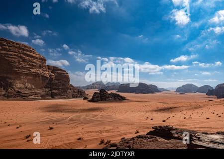 Deserto di Wadi Rum in Giordania in giorno di sole, sabbia e rocce, cielo blu Foto Stock