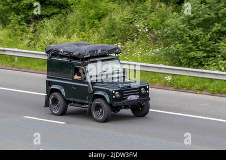 2002 verde Land Rover Defender pick-up TD5 spedizione SWB diesel camion; viaggiando sulla M61 autostrada, Manchester, Regno Unito Foto Stock