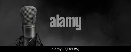 Microfono a condensatore da studio su sfondo nero con spazio per la copia Foto Stock