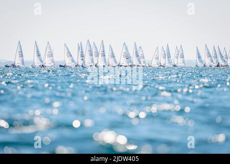 Kiel, Germania. 23rd giugno 2022. Vela: Kiel Week, di fronte al Centro Olimpico di Schilksee. Il grande campo di partenza nella classe barca ILCA7 nella retroilluminazione. Credit: Sascha Klahn/dpa/Alamy Live News Foto Stock