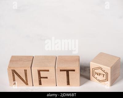 NFT testo su blocchi di legno come innovazione nel concetto di commercio di merci digitali Foto Stock