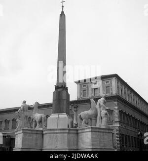 1950s, storica, alta colonna di pietra con croce religiosa cristiana in cima con stature di centurioni e cavalli alla base, Napoli, Italia. Foto Stock