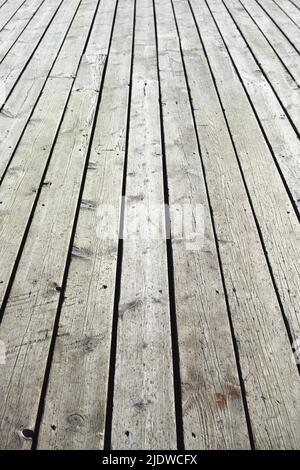 Primo piano di una superficie di legno di asse. Pavimento vintage grigio chiaro con doghe che formano una terrazza esterna. Vecchie strutture di legno duro pavimento usato come un Foto Stock