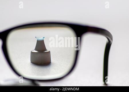 La lente a contatto blu attraverso gli occhiali neri mostra occhiali diversi per correggere la lungimiranza e la miopia da optometria o occhio medico miopia Foto Stock