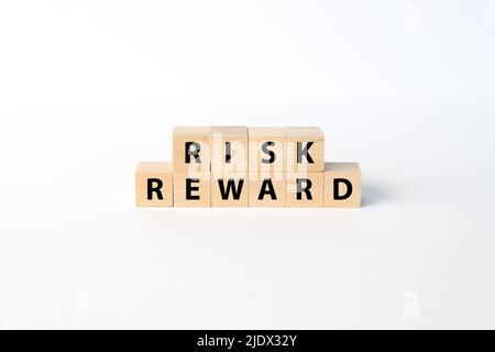 I concetti di rischio e ricompensa si sono espressi con blocchi di legno su sfondo bianco Foto Stock