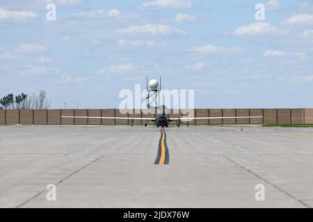 Gli airmen assegnati al 319th Aircraft Maintenance Squadron dalla base dell'aeronautica di Grand Forks, North Dakota, rimorchiano un RQ-4 Block 30 Global Hawk pilotato a distanza aereo 6 giugno 2022, attraverso la linea di volo della base dell'aeronautica di Grand Forks per Northrop Grumman a Grand Sky. Questo è stato il primo dei cinque blocchi RQ-4 30s ad essere trasferiti a Grand Sky per essere dotati di diverse tecnologie di sensori e iniziare a operare come parte del reparto Test System Test del Centro di Gestione risorse di prova. Situato sulla base dell'aeronautica di Grand Forks, il Grand Sky è un parco di affari e di aviazione focalizzato sullo sviluppo e lo sviluppo di Foto Stock