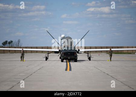 Gli airmen assegnati al 319th Aircraft Maintenance Squadron dalla base dell'aeronautica di Grand Forks, North Dakota, rimorchiano un RQ-4 Block 30 Global Hawk pilotato a distanza aereo 6 giugno 2022, attraverso la linea di volo della base dell'aeronautica di Grand Forks per Northrop Grumman a Grand Sky. Questo è stato il primo dei cinque blocchi RQ-4 30s ad essere trasferiti a Grand Sky per essere dotati di diverse tecnologie di sensori e iniziare a operare come parte del reparto Test System Test del Centro di Gestione risorse di prova. Situato sulla base dell'aeronautica di Grand Forks, il Grand Sky è un parco di affari e di aviazione focalizzato sullo sviluppo e lo sviluppo di Foto Stock