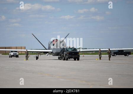 Gli airmen assegnati al 319th Aircraft Maintenance Squadron dalla base dell'aeronautica di Grand Forks, North Dakota, rimorchiano un RQ-4 Block 30 Global Hawk pilotato a distanza aereo 6 giugno 2022, attraverso la linea di volo della base dell'aeronautica di Grand Forks per Northrop Grumman a Grand Sky. Il blocco RQ-4 30 della dismissione fa parte del piano dell'aviazione militare statunitense di ristrutturare l'intelligence, la sorveglianza e la ricognizione per soddisfare le priorità nazionali di difesa e supportare capacità comuni di comando e controllo a tutti i domini. Situato sulla base dell'aeronautica di Grand Forks, il Grand Sky è un parco di affari e di aviazione focalizzato sullo sviluppo e lo sviluppo di Foto Stock