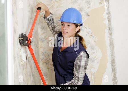 donna con pinze che lavorano in ambienti interni Foto Stock