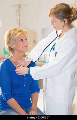 medico sorridente che controlla la frequenza cardiaca del paziente Foto Stock