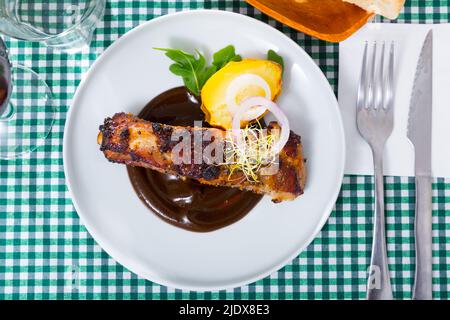 Vista dall'alto delle costolette di maiale in salsa di cioccolato con patate al forno Foto Stock