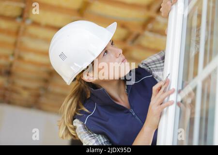 donna costruttore che lavora su una finestra in pvc Foto Stock