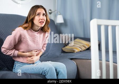 Giovane donna che soffre di dolori addominali Foto Stock