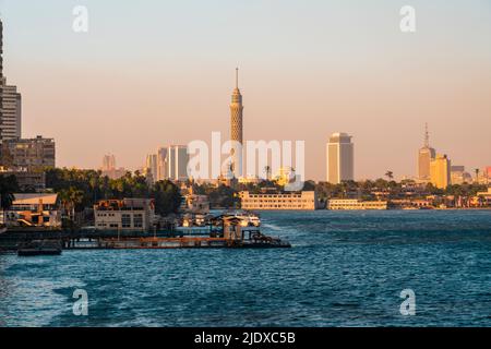 Egitto, Cairo, molo nel quartiere di Gezira al tramonto con la Torre del Cairo e lo skyline del centro in background Foto Stock
