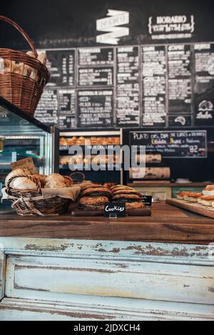 Biscotti disposti da un cestino di pane sul tavolo in panetteria Foto Stock