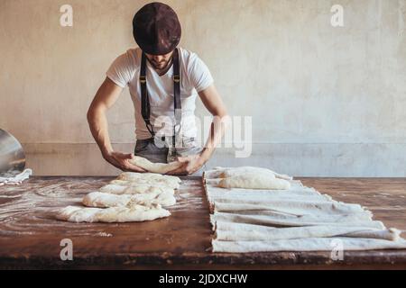 Panettiere arrangiare l'impasto su tovagliolo per la preparazione in panetteria Foto Stock