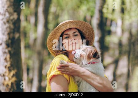 Donna che porta il cane nella foresta Foto Stock