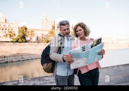 Turisti maturi leggendo la mappa in città in vacanza Foto Stock