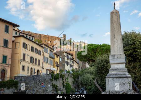 Italia, Provincia di Arezzo, Cortona, Monumento a Piazza Garibaldi con case cittadine sullo sfondo Foto Stock
