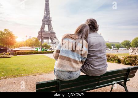 Coppia matura seduta insieme sulla panchina del parco ammirando la Torre Eiffel, Parigi, Francia Foto Stock