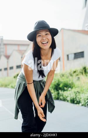 Ragazza allegra che indossa un cappello godendosi il giorno di sole Foto Stock