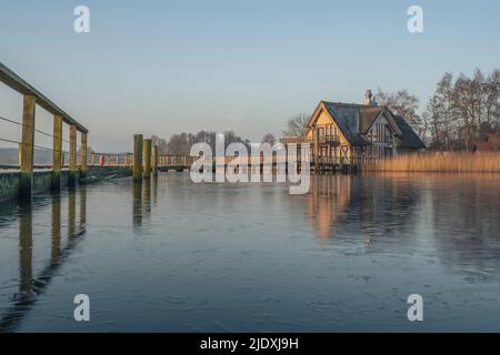 Germania, Schleswig-Holstein, Hemmelsdorf, molo sulla riva di Hemmelsdorfer vedere con casa in background Foto Stock