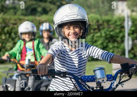 Sorridendo indossando il ragazzo casco sportivo che ride quadbike all'allenamento di educazione al traffico Foto Stock