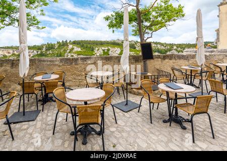 Un caffè all'aperto con vista sulle montagne delle Alpilles e sulla valle di Les Baux a Les Baux-de-Provence, nella regione della Provenza nel sud della Francia. Foto Stock