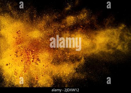Esplosione, schizzi di curcuma su sfondo nero. India Seasoning. La polvere arancione della radice curmerica. Foto Stock