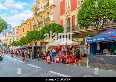 Gli spettatori delle gare camminano davanti alle cabine che vendono materiale da corsa e di Formula uno durante il Gran Premio di Monaco a Monte Carlo, Monaco. Foto Stock