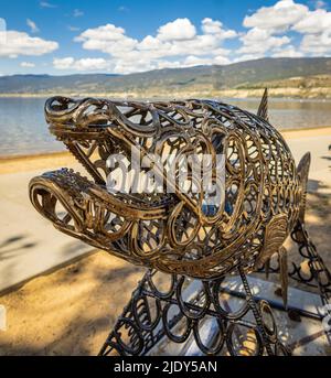 Scultura in metallo di pesce su una spiaggia di Penticton BC Canada. Oggetto d'arte a forma di pesce di salmone Foto Stock