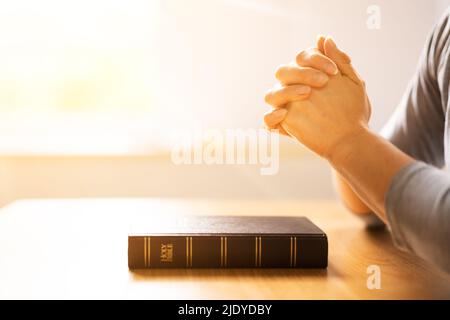 Luce del sole che cade sulla mano della donna sopra il Libro della Bibbia santo Foto Stock