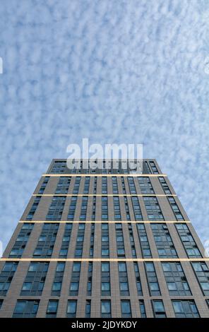 Vista astratta che guarda agli angoli di un edificio moderno contro un cielo blu e bianco delle mottelle Foto Stock