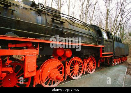 Locomotiva a vapore parcheggiata in una stazione terminale. Ferrovia storica dal 1940 in rosso nero. Nostalgia foto della tecnologia passata Foto Stock