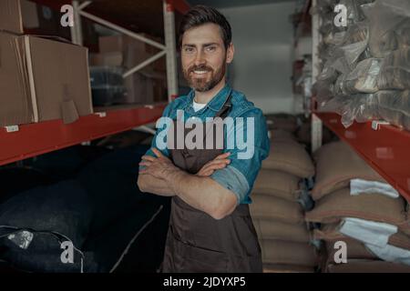 Ritratto del lavoratore di magazzino in uniforme di piccola fabbrica di caffè Foto Stock