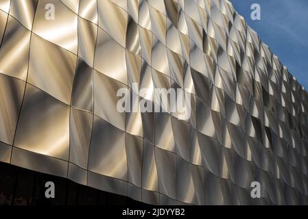 Design scultoreo contemporaneo, edificio rivestito in pannelli metallici formati nel 3D. I pannelli perforati nascondono le finestre. Architettura moderna. Foto Stock