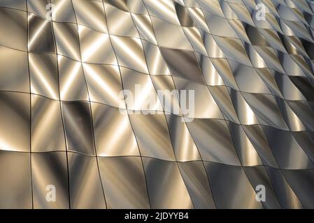 Design scultoreo contemporaneo, edificio rivestito in pannelli metallici formati nel 3D. I pannelli perforati nascondono le finestre. Architettura moderna. Foto Stock