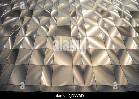 Design scultoreo contemporaneo, edificio rivestito in pannelli metallici formati nel 3D. I pannelli perforati nascondono le finestre. Architettura moderna. Foto Stock