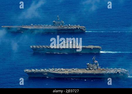 Mar delle Filippine. 12th giugno 2022. Gli Stati Uniti Navyâs solo portaerei schierati in avanti USS Ronald Reagan (CVN 76), USS Tripoli (LHA 7) e USS Abraham Lincoln (CVN 72), vapore in formazione durante Valiant Shield 2022 (VS22). VS22 è un'esercitazione biennale di formazione sul campo (FTX), riservata agli Stati Uniti, incentrata sull'integrazione della formazione congiunta in un ambiente multi-dominio. Questa formazione sviluppa una competenza reale nel sostenere le forze congiunte attraverso il rilevamento, l'individuazione, il tracciamento e l'impegno delle unità in mare, in aria, a terra e nel ciberspazio in risposta a una serie di aree di missione. (Credit Image: © U.S. Navy Foto Stock